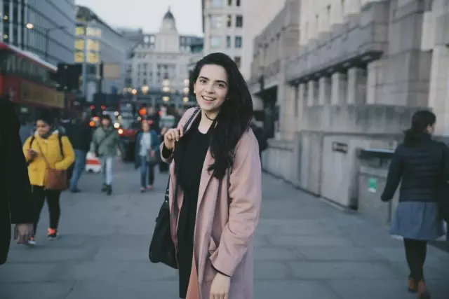 Woman stands on London Bridge for photoshoot in Pink Jacket